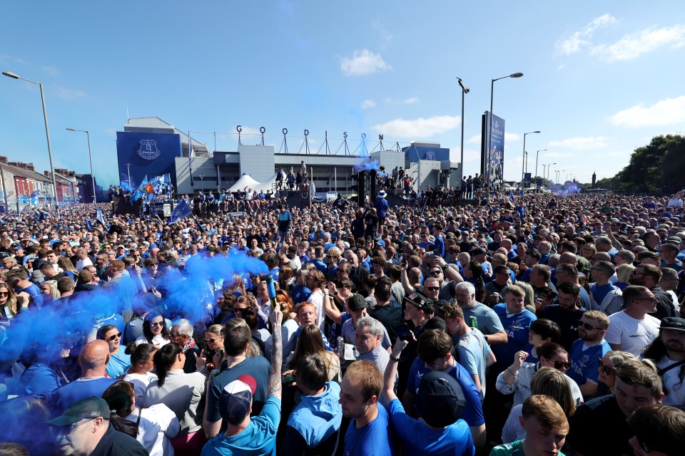 Everton fans with blue flares outside Goodison Park.