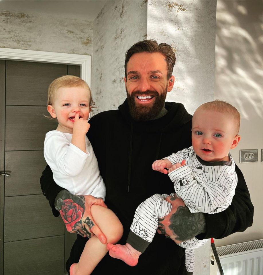 Aaron Chalmer holding his two young children.