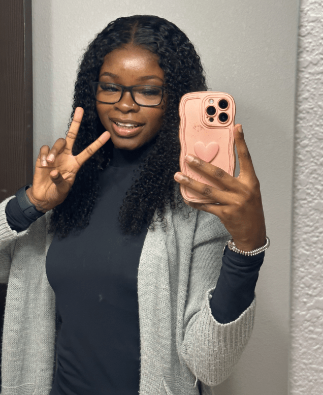 Selfie of a woman making a peace sign.