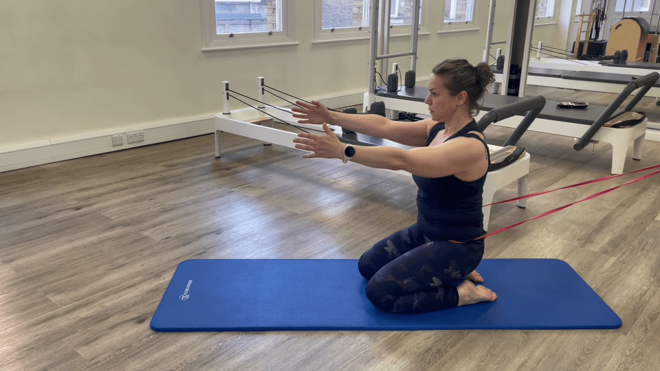 Woman doing Pilates leg exercises with resistance bands.