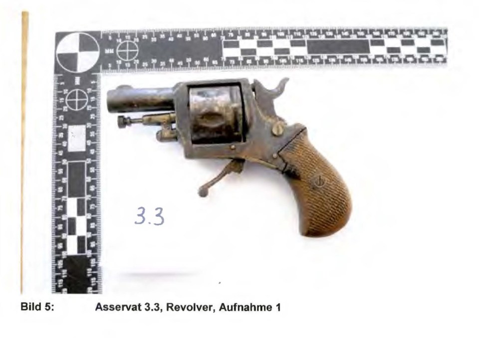 Photo of a revolver next to a ruler.