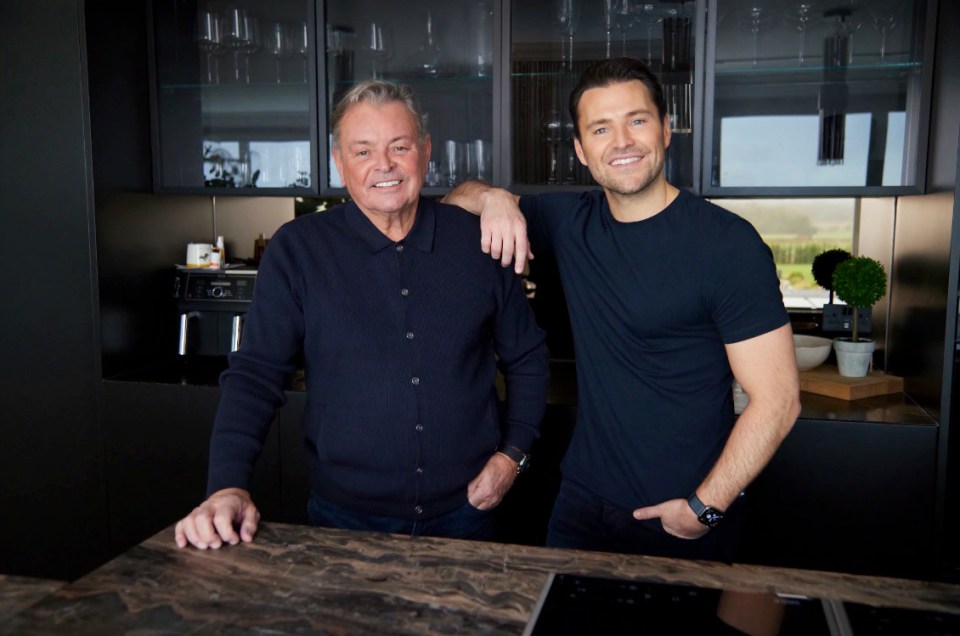 Mark Wright and his father posing together in a kitchen.