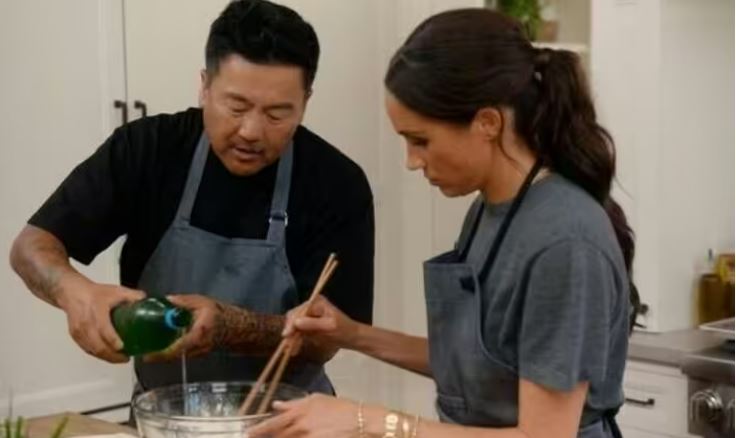 Meghan Markle and a chef preparing food together.
