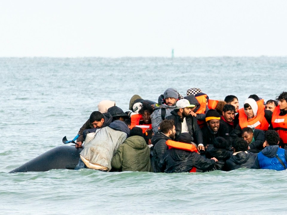 Migrants in a small boat at sea.