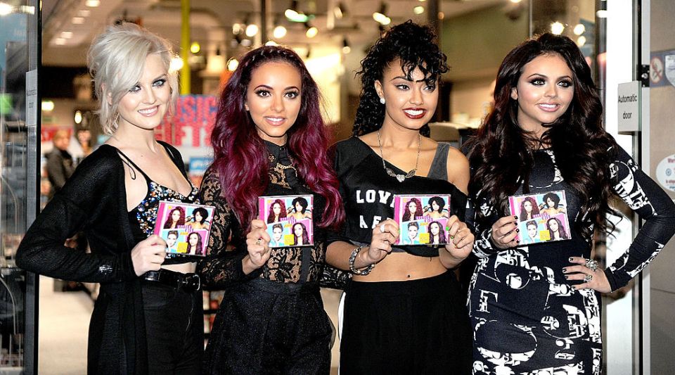 Little Mix signing autographs and posing with their album, *DNA*.