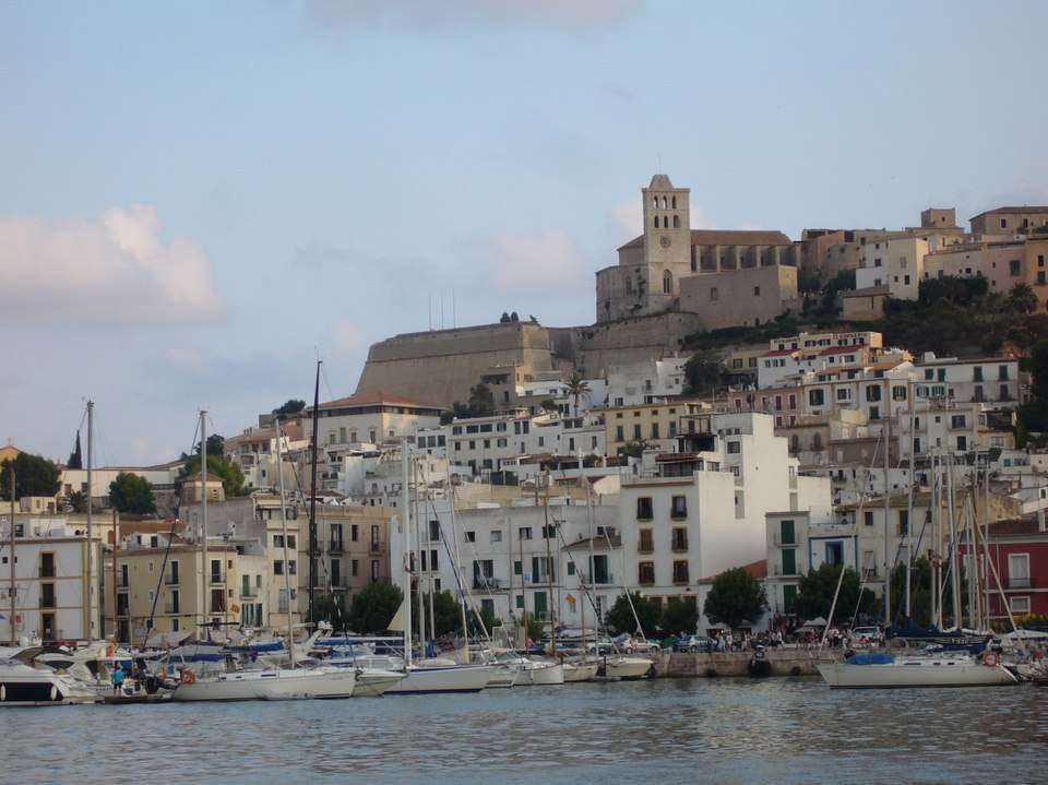Ibiza town and marina with boats and a hilltop cathedral.