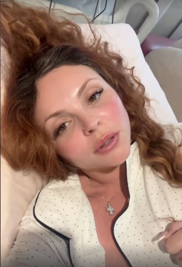 Jesy Nelson lying in a hospital bed.