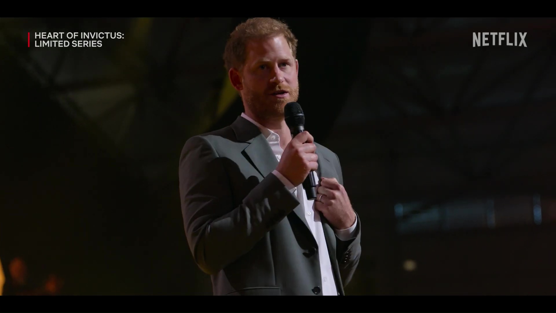 Prince Harry giving an emotional statement at a microphone.