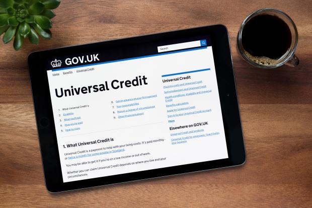 iPad displaying the UK government website's Universal Credit page.
