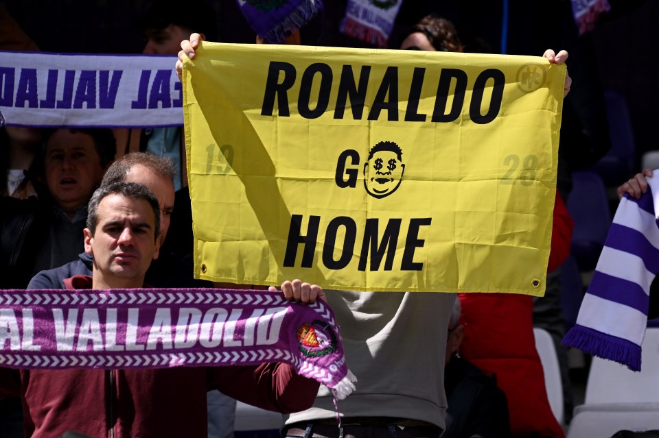 A Real Valladolid CF fan holds a sign that says "Ronaldo Go Home."