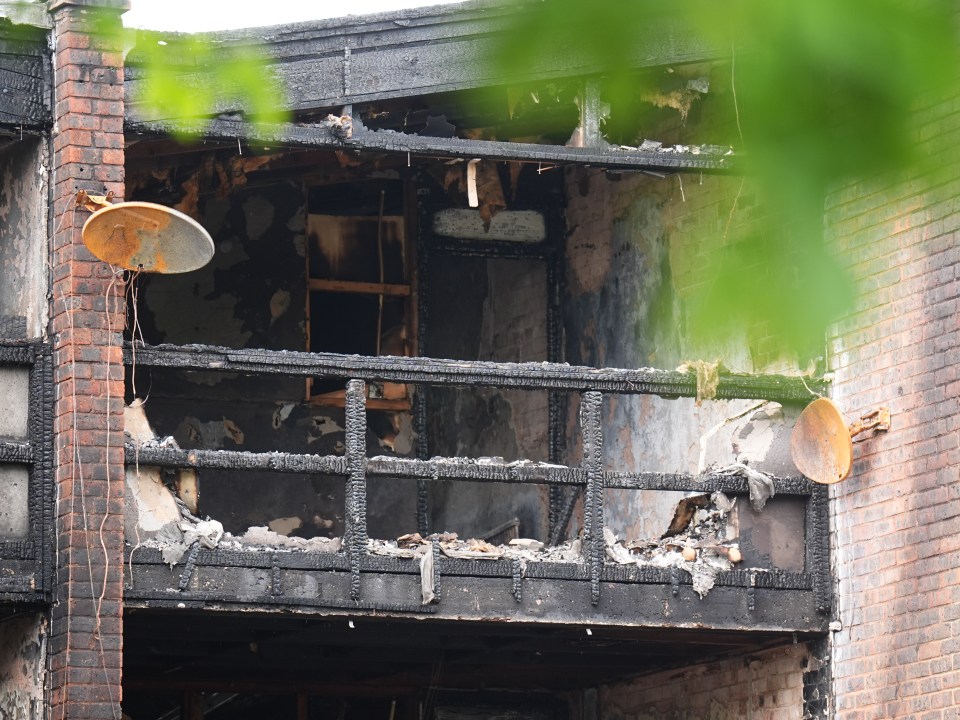 Fire-damaged balcony of a brick building.