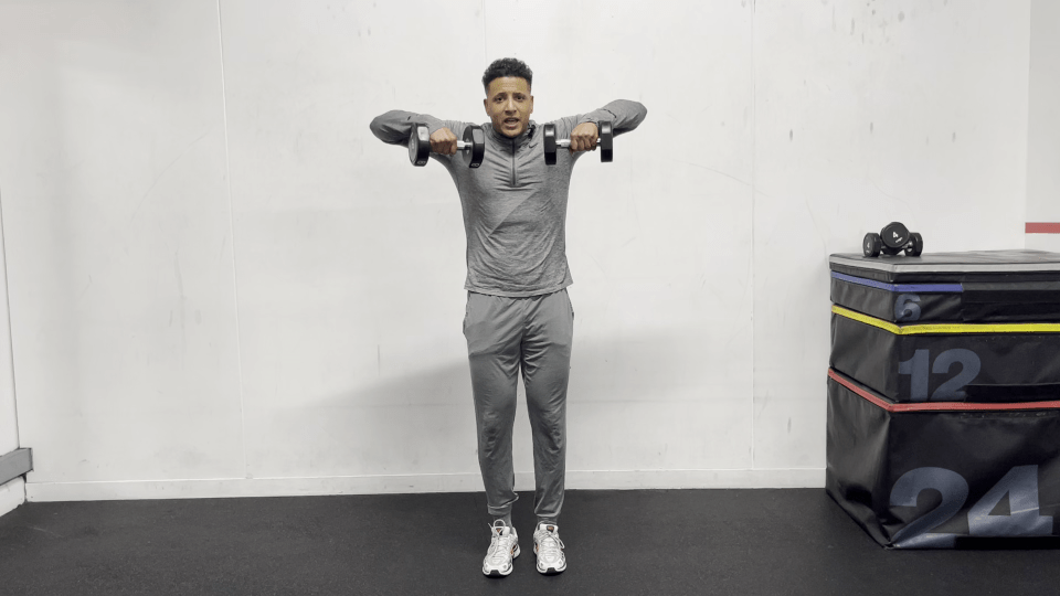 Man performing a dumbbell lateral raise exercise.