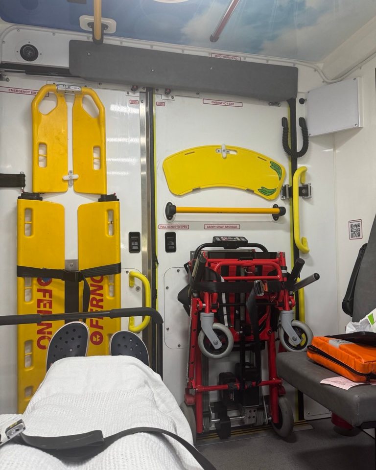 Ambulance interior with patient, stretcher, and wheelchair.